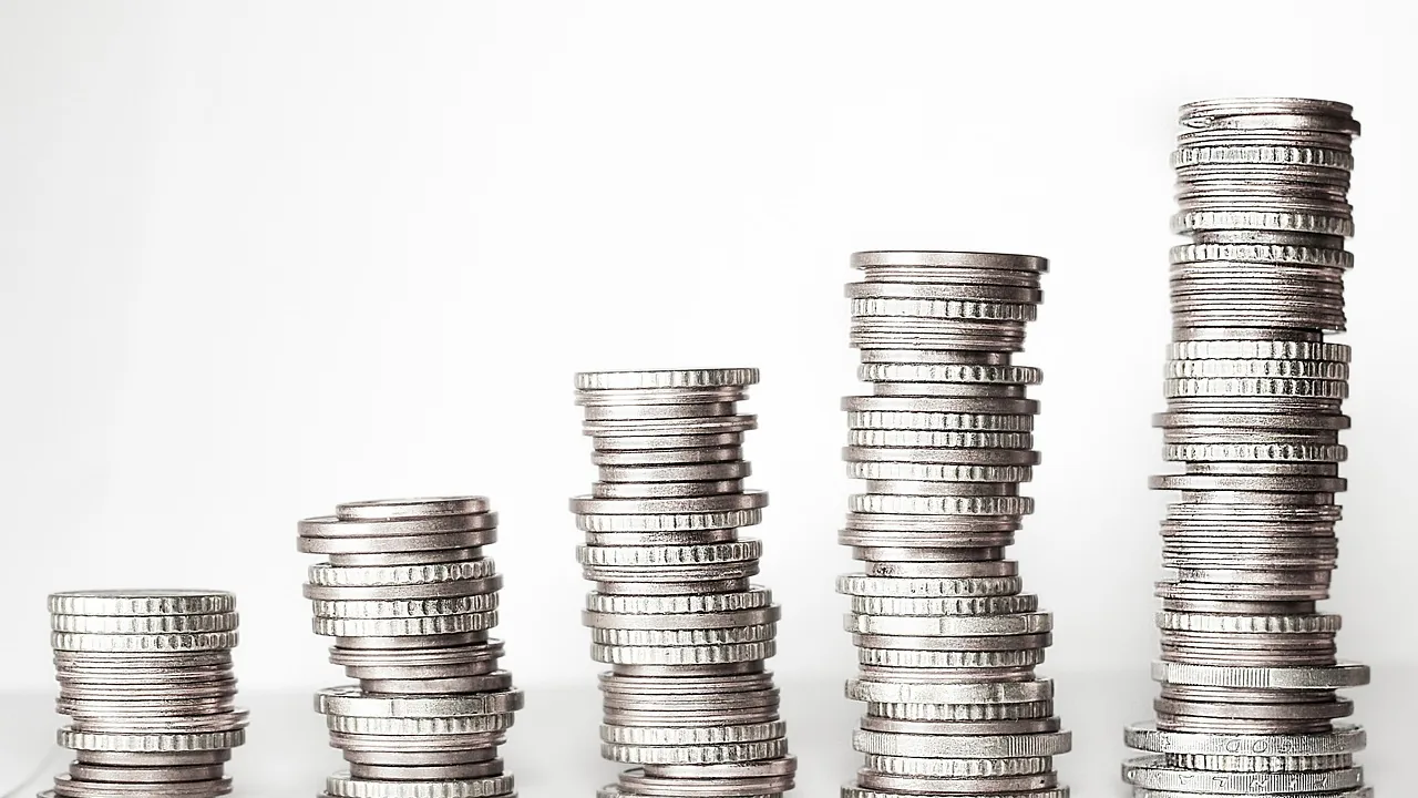 Piles de pièces de monnaie de hauteur croissante, image d'une somme placée sur un compte épargne pendant 1 an